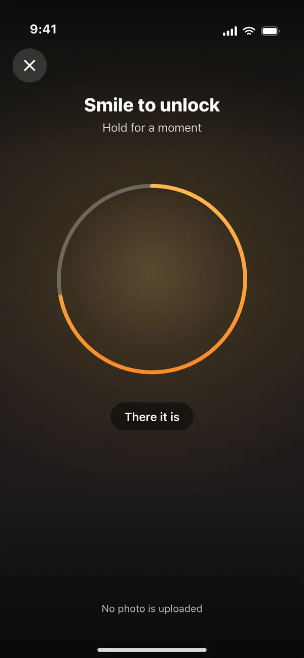 The smile scan - the front camera viewfinder with orange corner brackets asking for a natural smile, with the note that no photo is uploaded